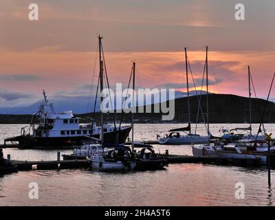 Boats in bay at sunset, Oban, Scotland Stock Photo