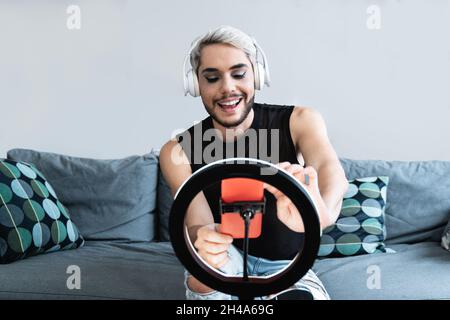 Transgender man with makeup on streaming live video on social media with mobile phone app - Lgbt, equality and technology lifestyle concept Stock Photo
