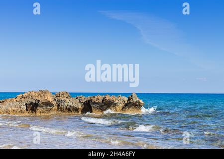 Sea waves break on rocky shores in clear weather. Waves crash on the beach. Wave on the surface of the sea. Natural background. travel Stock Photo