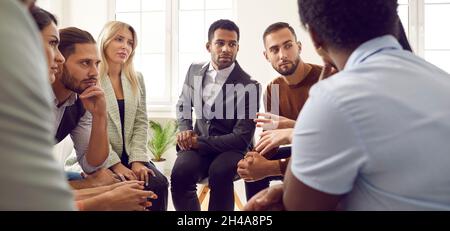 Team of serious young diverse business people discussing something in work meeting Stock Photo