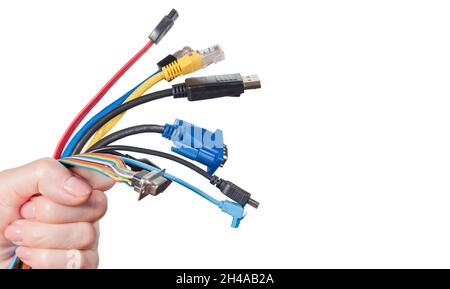 Bunch of computer cables in women's hand isolated on white background. Bundle of computer interface cables with different connectors Stock Photo