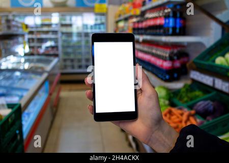 Woman using cellphone, mockup image of female hand holding mobile phone with blank white screen at shopping. Stock Photo