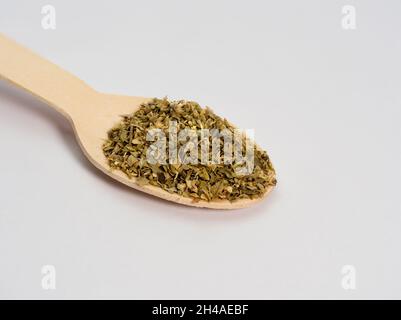 marjoram on a wooden spoon spice used in the kitchen, macro photo lots of details, white background, eco concept Stock Photo