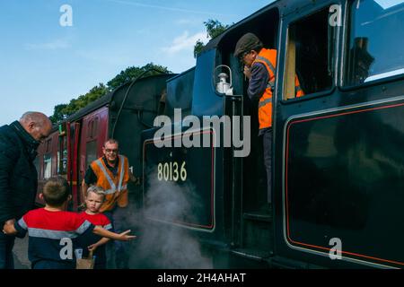 Adult and children enjoying a steam train with friendly train drivers, The Moorlander 8136, Grosmont station, North York Moors heritage railway, UK Stock Photo