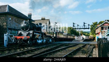 Grosmont station with a steam train leaving the station and puffing smoke, North York Moors Railway, UK Stock Photo