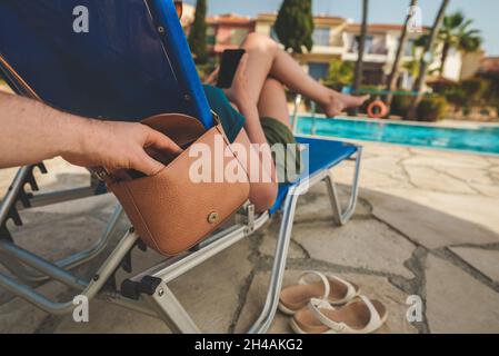 Thief stealing a bag from a woman on vacation. Stock Photo