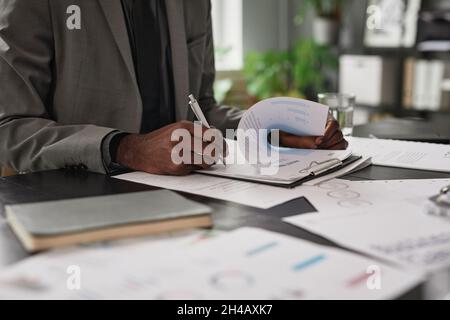 Close up of successful black businessman signing contract at desk in office, copy space Stock Photo
