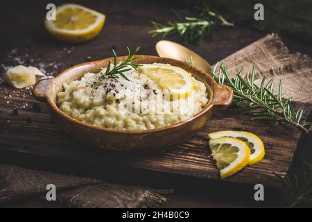 Lemon rice risotto with rosemary on dark wooden background Stock Photo