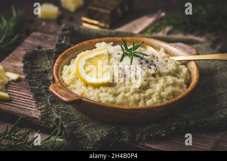 Lemon rice risotto with rosemary on dark wooden background Stock Photo