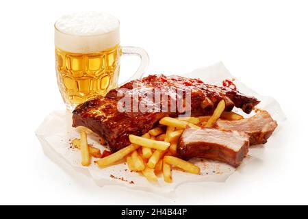 Closeup shot of barbeque pork spareribs and French fries served with a glass of lager beer Stock Photo