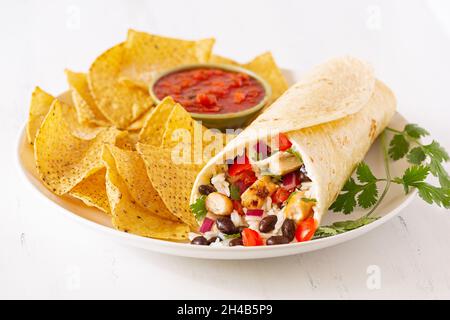 Fresh chicken and black bean burrito with tortilla chips and salsa Stock Photo