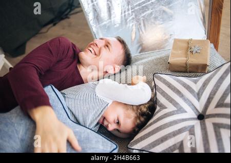 Father and son playing pillow fight on the bed Stock Photo