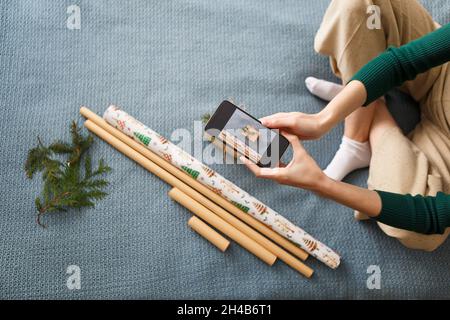 Young woman takes pictures of freshly wrapped christmas presents Stock Photo