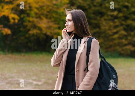 Young brunette girl talking on the mobile phone outdoor Stock Photo