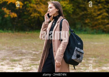 Young brunette girl talking on the mobile phone outdoor Stock Photo