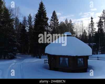 Wooden made red cabins in a forest. Snowy weather. Stock Photo
