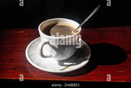 A cup of coffee on a saucer, with a coffee spoon in it, Cartagena de Indias, Colombia. Stock Photo