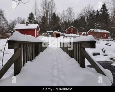 Wooden made red cabins in a forest. Snowy weather. Stock Photo