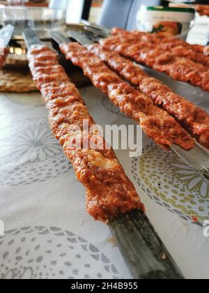 Minced meat on thick metal skewers called shish kebab in Turkish. Stock Photo