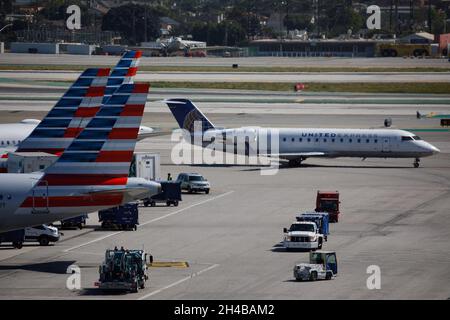 Los Angeles, California, USA. 28th Mar, 2019. A United Airlines United Express Bombardier CRJ-200ER (Registration N965SW) taxis past American Airlines aircraft on the tarmac at Los Angeles International Airport (LAX) on Thursday, March 28, 2019 in Los Angeles, Calif. © 2019 Patrick T. Fallon (Credit Image: © Patrick Fallon/ZUMA Press Wire) Stock Photo
