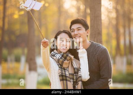Happy young couple taking selfies with their mobile phone Stock Photo