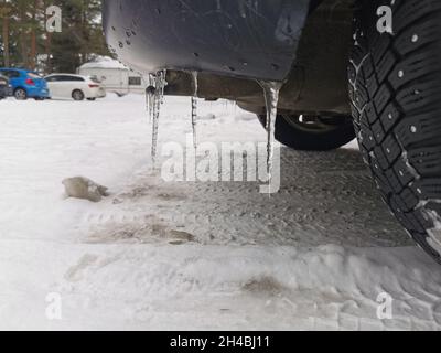 Ice shards coming down from a car rear bumper. Stock Photo