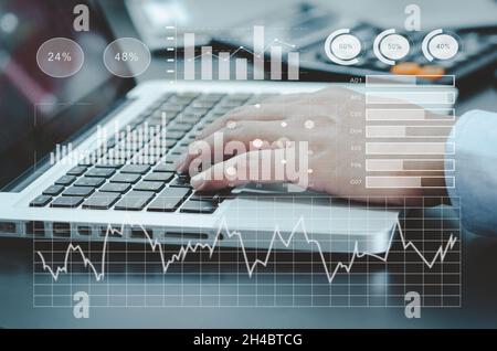 businessman typing computer laptop on desk. chart and graph virtual screen hologram. business technology concept Stock Photo