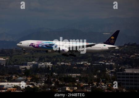 Los Angeles, California, USA. 28th Mar, 2019. An Saudi Arabian Airlines Boeing Co 777-300 (Registration HZ-AK43) passes the Hollywood sign as it lands at Los Angeles International Airport (LAX) on Thursday, March 28, 2019 in Los Angeles, Calif. © 2019 Patrick T. Fallon (Credit Image: © Patrick Fallon/ZUMA Press Wire) Stock Photo