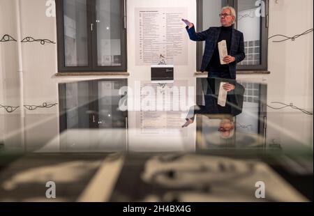 11 October 2021, Lower Saxony, Lüneburg: Carsten Junge, director of the Kunsthalle der Sparkassenstiftung Lüneburg, is standing next to a golden Grammy, which Klaus Voormann received for the Best Album Cover. Klaus Voormann is considered the fifth Beatle, he met the Beatles in 1960 in the Kaiserkeller on St. Pauli. In the Kultur Bäckerei Lüneburg an exhibition is dedicated to his life's work for the first time. (to dpa 'Klaus Voormann - no one was as close to the Beatles') Photo: Philipp Schulze/dpa Stock Photo