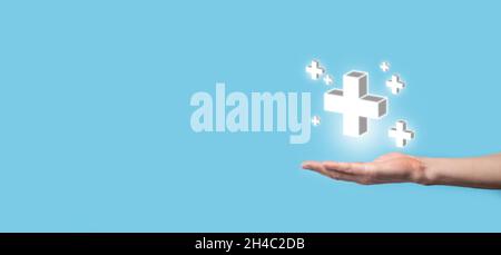 Hand hold 3D plus icon, man hold in hand offer positive thing such as profit, benefits, development, CSR represented by plus sign.The hand shows the p Stock Photo