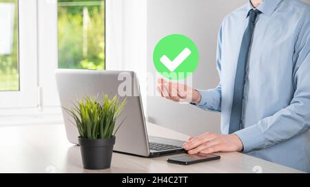 Hand holds green icon Check mark,Check Mark Sign, Tick Icon,right sign,circle green checkmark button,Done.On dark background.Banner.Copy space.Place f Stock Photo