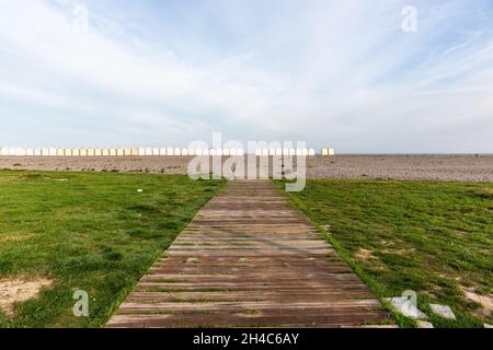 Gateway to the sea, on a pebble beach. Line of beach huts on the horizon. Cayeux-sur-Mer, Opal Coast, France Stock Photo