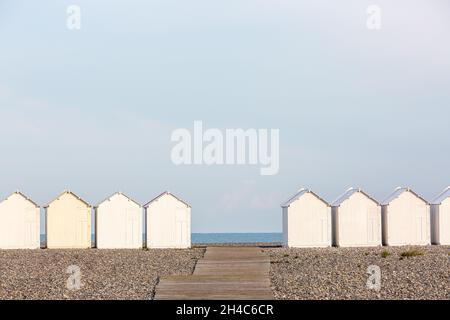 Alignment of white beach cabins, facing the sea, on Cayeux-sur-Mer beach. Opal Coast, France Stock Photo