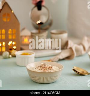 Rice pudding. Woman pouring coffee from coffee maker to cup. Christmas decoration Stock Photo