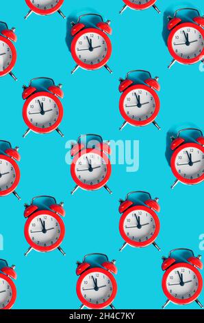 many red alarm clocks on blue background, pattern with hard light time concept, new year or christmas background. Winter holiday concept, flat lay, Te Stock Photo