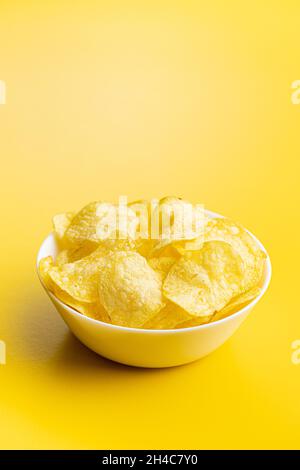 Crunchy potato chips. Potato crisps on yellow background. Stock Photo