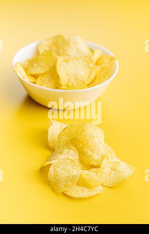 Crunchy potato chips. Potato crisps on yellow background. Stock Photo