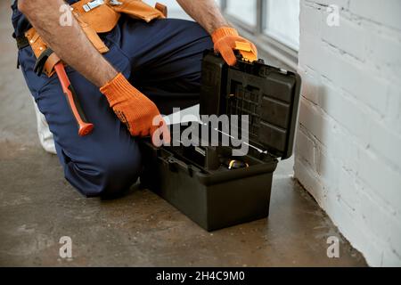 Male electrician in work gloves using tool box Stock Photo