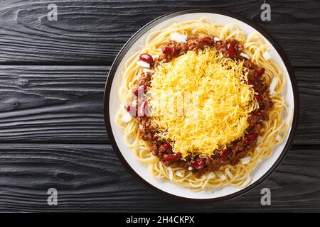 Cincinnati style chili 5 way close up in the plate on the black wooden background. Horizontal top view from above Stock Photo