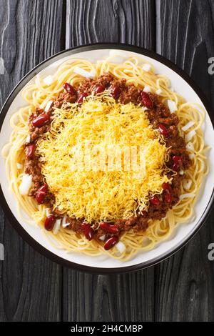 Cincinnati chili or Cincinnati style chili is a Mediterranean spiced meat sauce used as a topping for spaghetti closeup in the plate on the black tabl Stock Photo