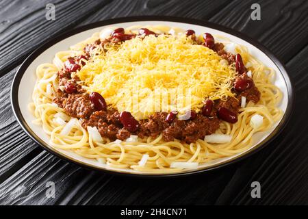 American food Cincinnati chili with spaghetti, cheddar cheese and beans close-up in a plate on the table. horizontal Stock Photo