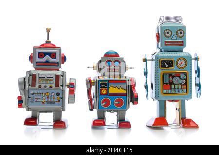 Three retro style sheetmetal toy robots on white background Stock Photo