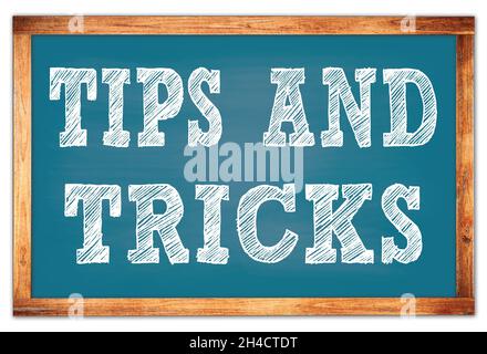 TIPS AND TRICKS written on blue wooden frame school blackboard Stock Photo