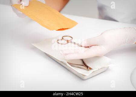 Master of manicure sterilizing manicure scissors. Disinfection of manicure tools Stock Photo