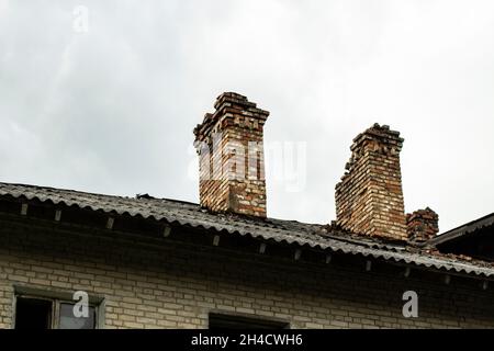 Old roof with chimneys. Old house. A crumbling building. Stock Photo