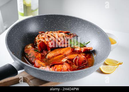 Cooking raw lobster in a deep frying pan Stock Photo