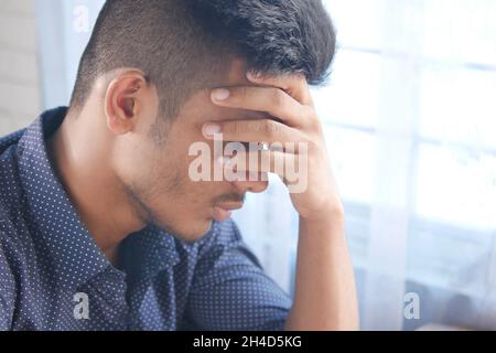 Depressed man feeling sick and worried about financial problem Stock Photo
