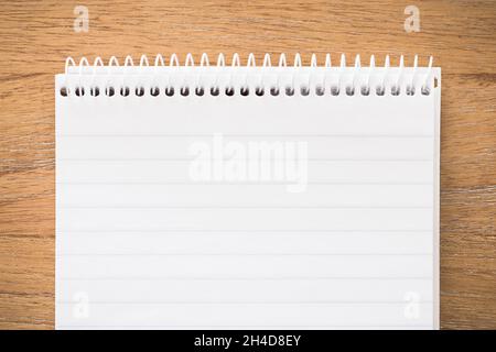 Spiral notebook secretary note pad on a wooden desk. Flat lay template or background Stock Photo