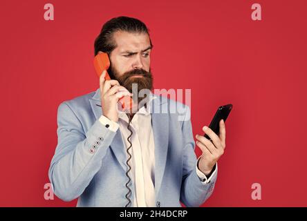 Expect the Best. Evolution of communication devices. Retro man talking on phone. Modern mobile phone and old vintage classic telephone. Technology is Stock Photo