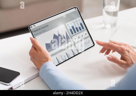 Mature caucasian businesswoman use financial application, managed funds on tablet screen at workplace Stock Photo